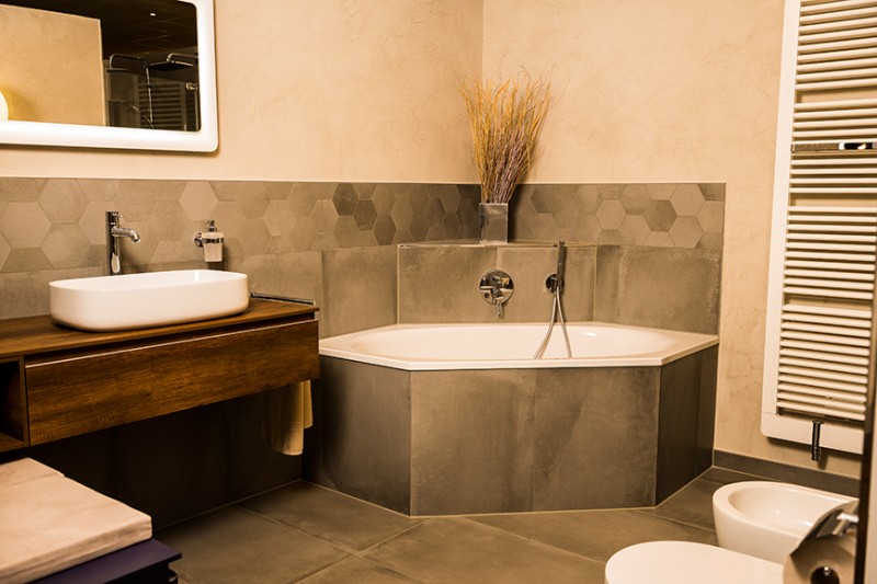 Modernes Badezimmer mit Badewanne – stilvolle Badgestaltung und Komfort Modern gestaltetes Badezimmer mit Eckbadewanne, Waschtisch und hochwertigen Fliesen für mehr Wohnkomfort